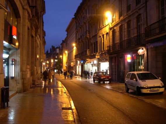  Grande rue éclairée par quelques lampadaires à la tombée de la nuit.